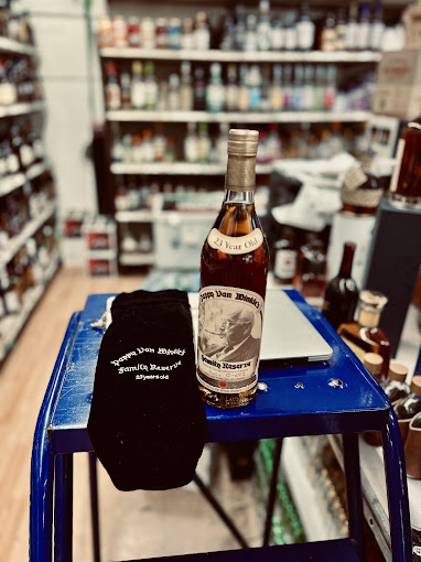 Pappy Van Winkle Family Reserve 23-year bottle beside its velvet bag.
