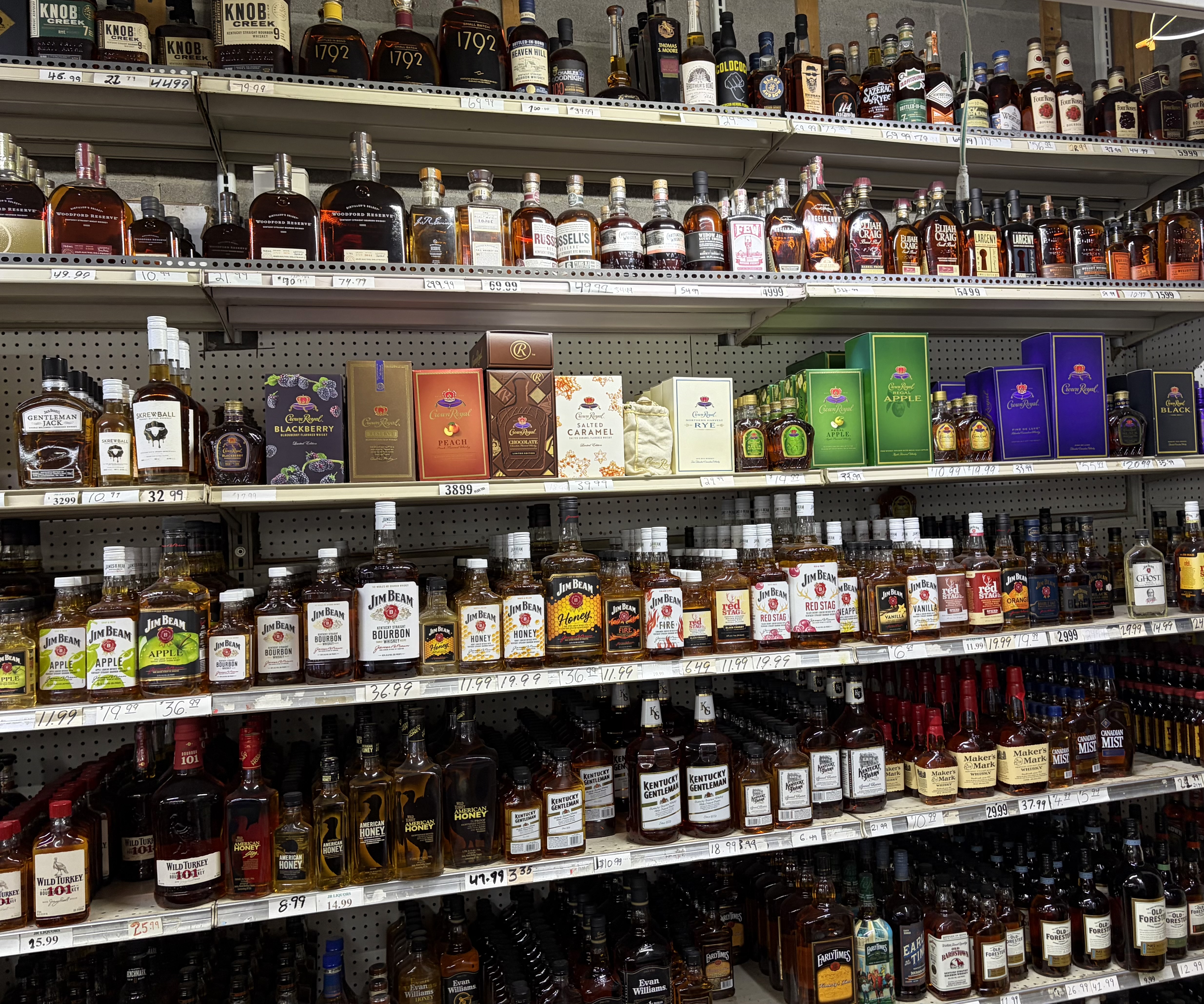 Shelves of bourbon and whiskey including Knob Creek, Woodford Reserve, Elijah Craig, Four Roses, Jim Beam, Maker's Mark and Crown Royal.