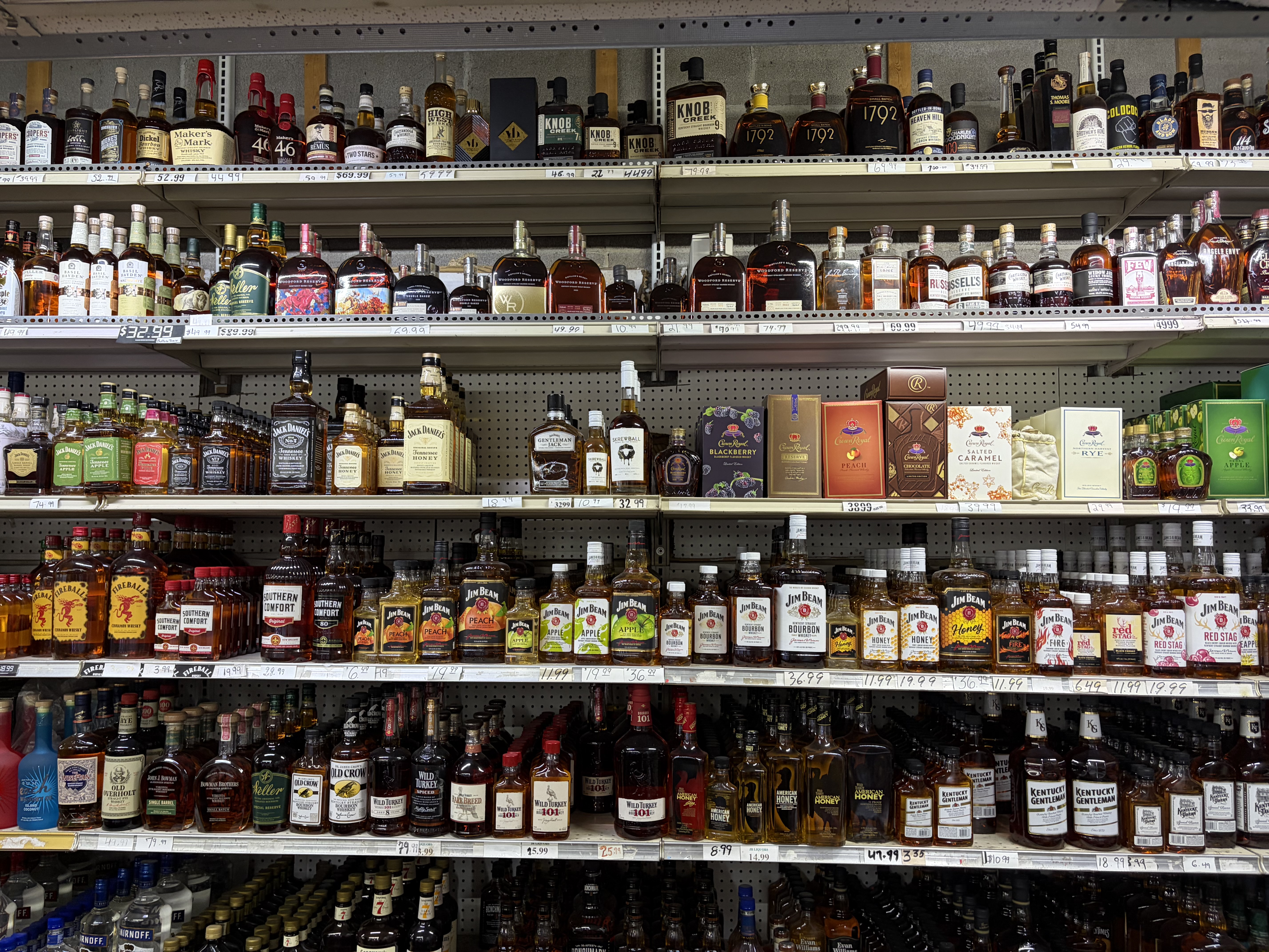 Bourbon and whiskey aisle shelves including Maker's Mark, Knob Creek, Jack Daniel's, Woodford Reserve and Jim Beam.