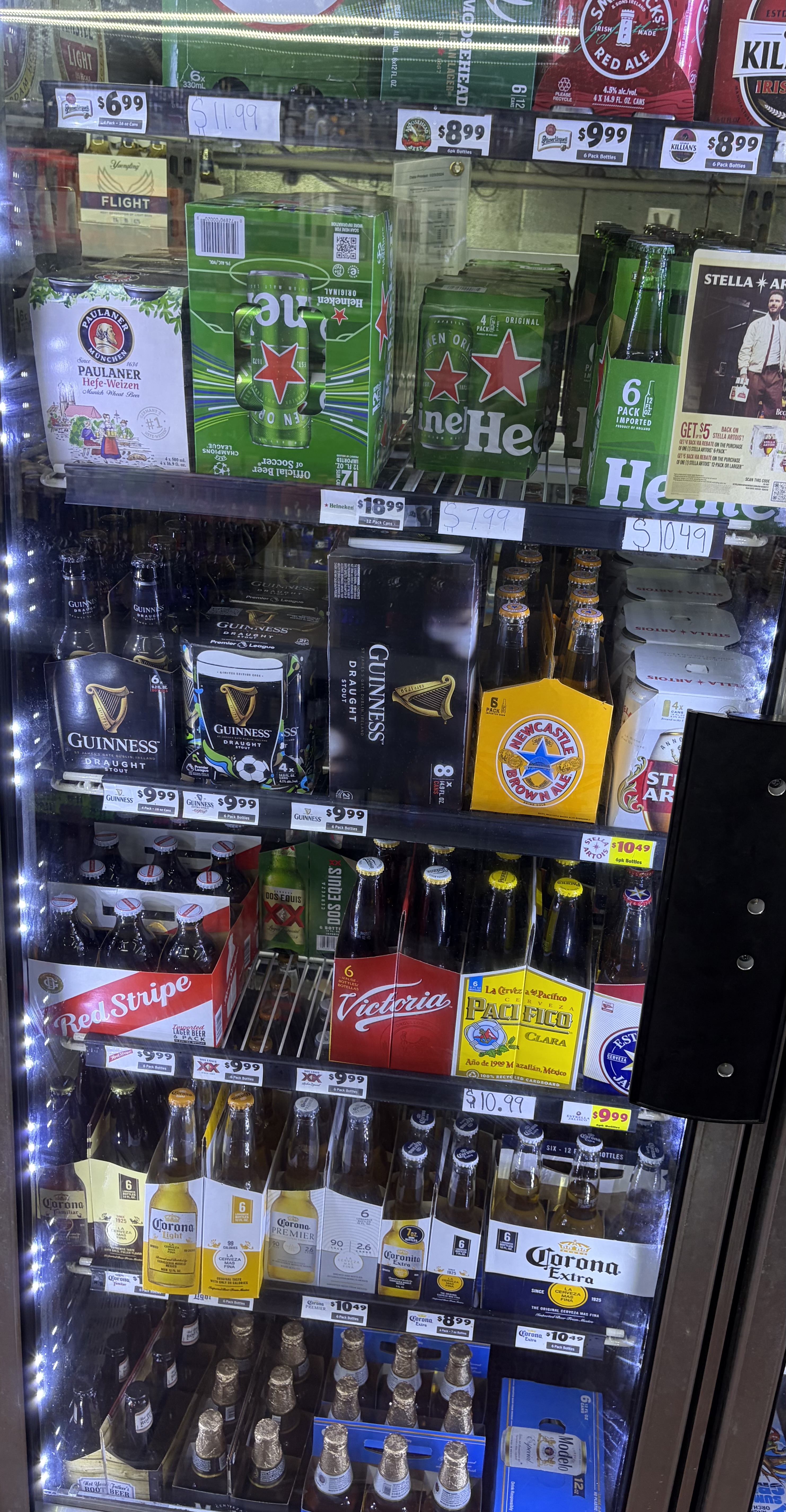 Refrigerated import beer including Heineken, Guinness, Corona and Pacifico bottles.