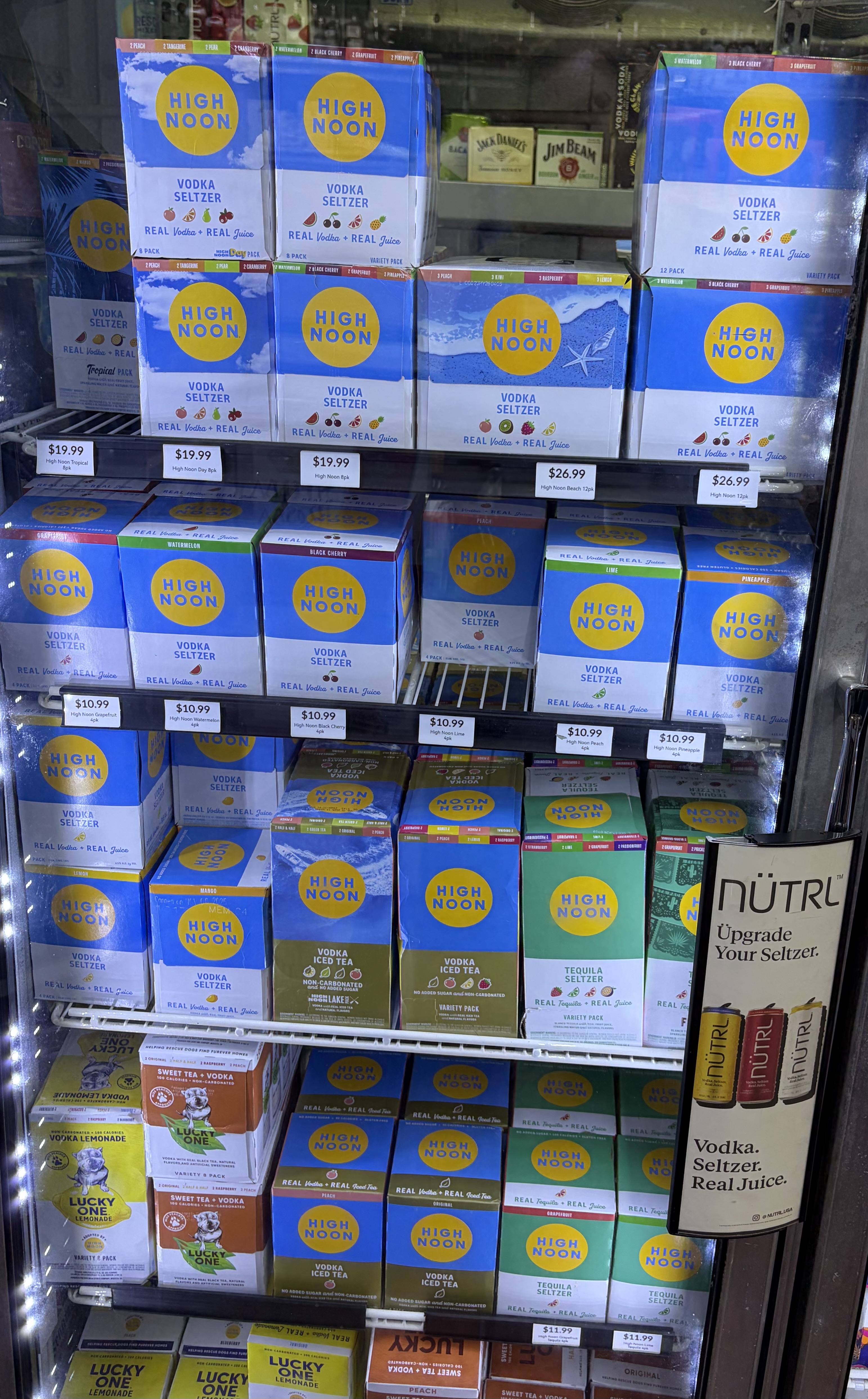 Boxes of High Noon vodka seltzer variety packs and Nutrl.