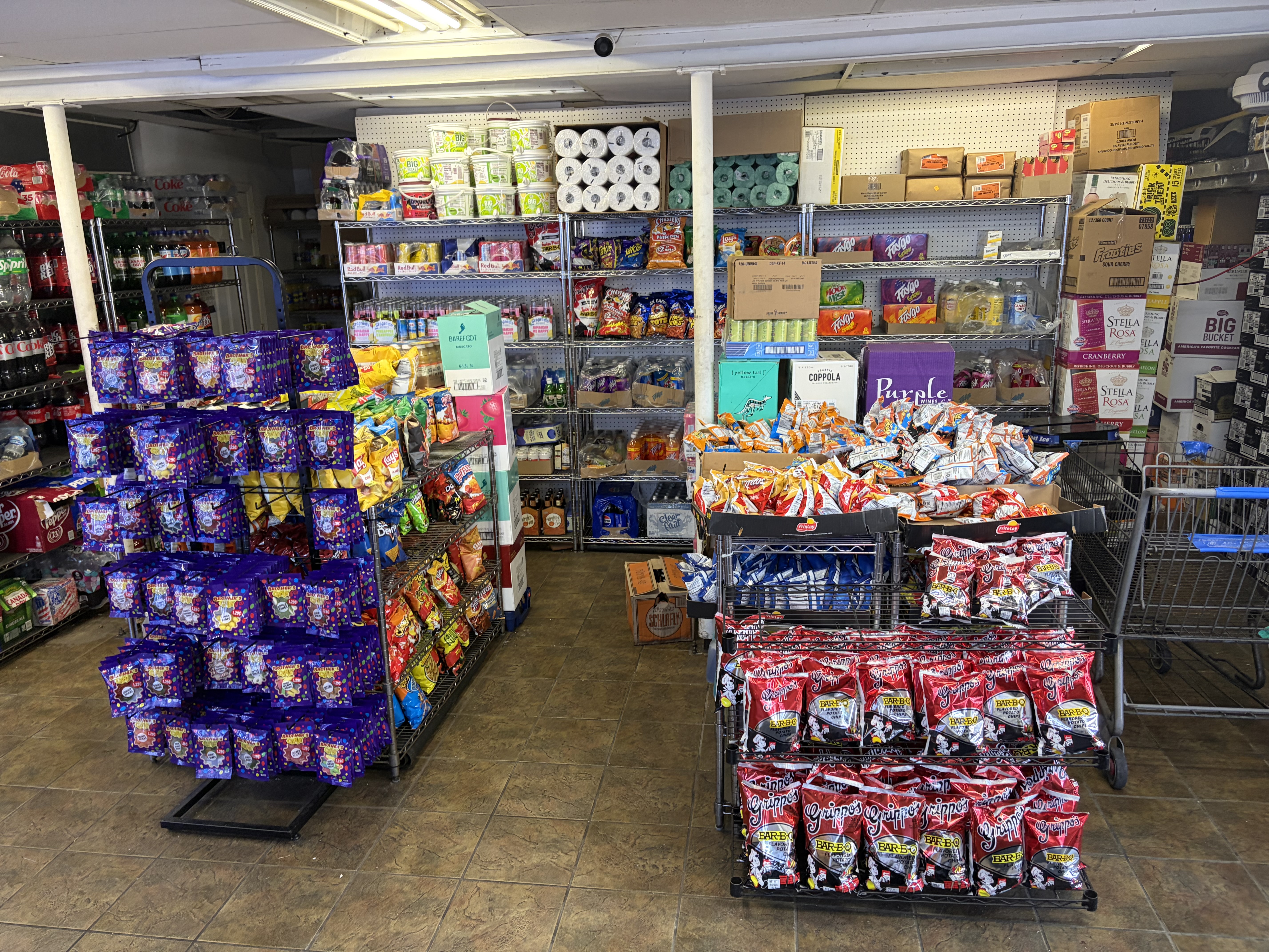 Store interior showing chips like Grippo's and Lay's, candy racks, soda and convenience items.